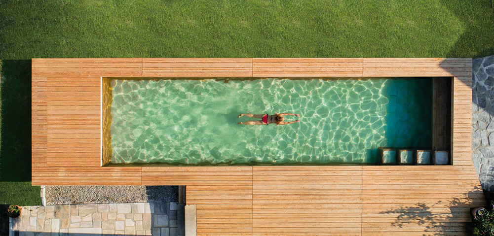 Lady swimming in the Holc natural pool. Healthy water, no chemicals, just pure swimming pleasure.