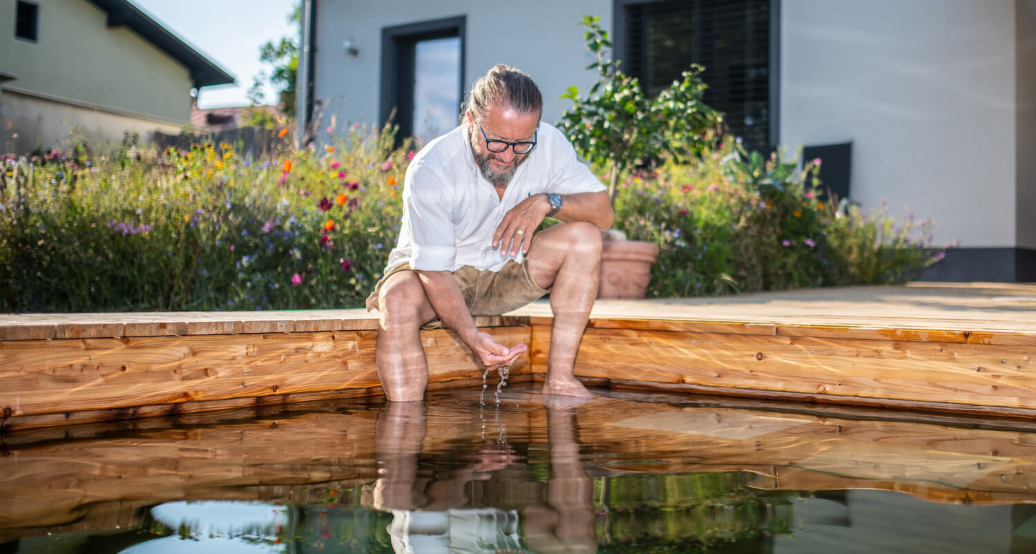 Herbert Laßnig der CEO sitzt am Holc Naturpool