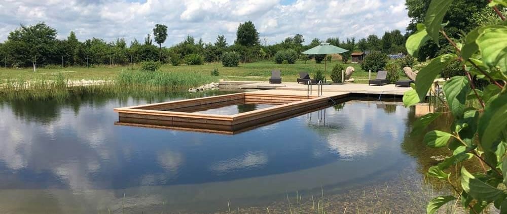 Zeigt einen Naturpool aus Holz in einem Teich
